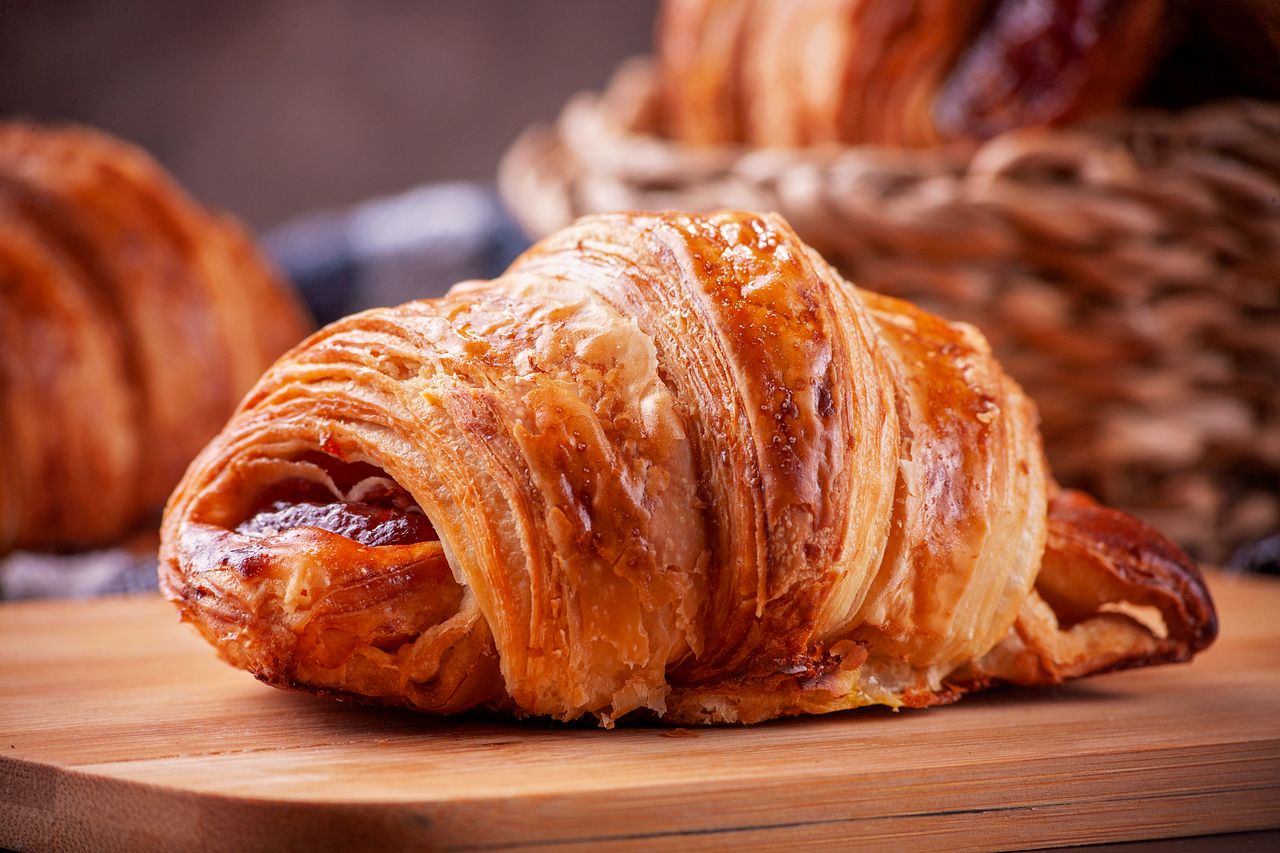 The Art of Drawing Readers In: Your attractive post title goes here Close-up of a golden, flaky croissant on a wooden board, perfect for breakfast visuals.