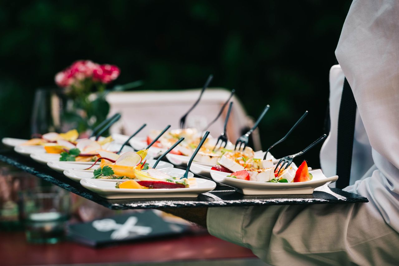 Home Gourmet appetizers elegantly served on tray at outdoor event, highlighting culinary artistry.